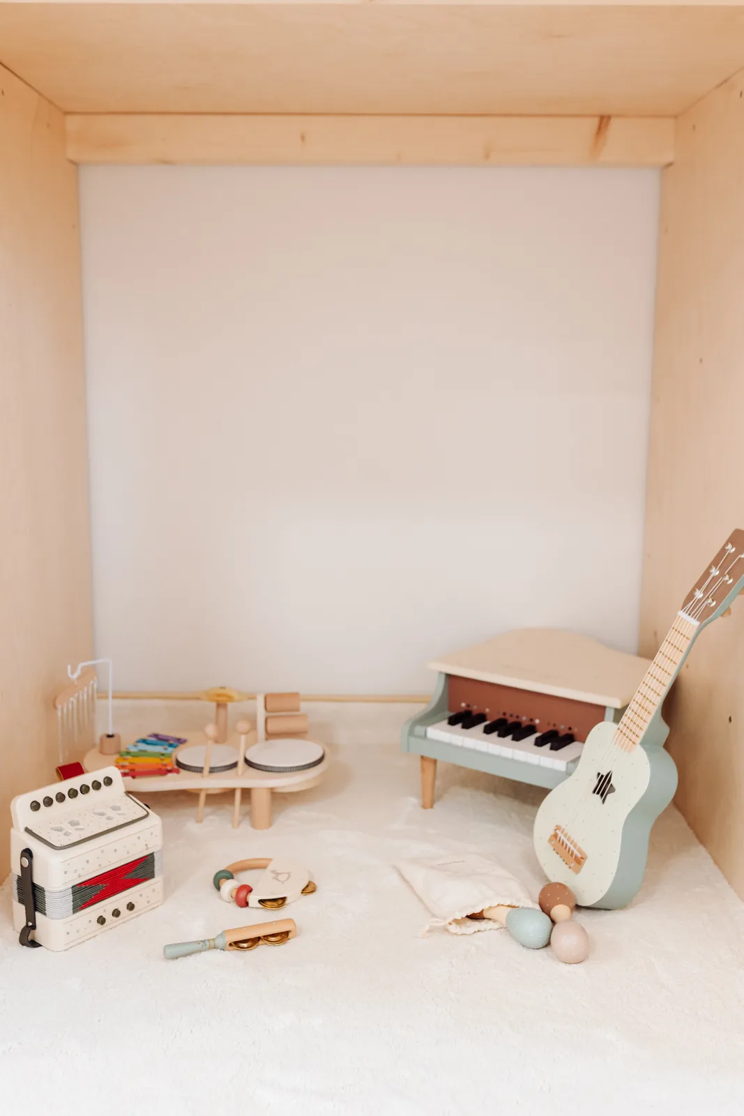 Kącik muzyczny z drewnianymi instrumentami — pianino, gitara i cymbałki w Bawisz