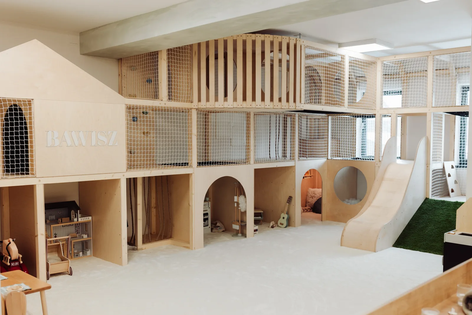 Drewniana sala zabaw Montessori ze zjeżdżalnią i piętrową konstrukcją w Bawisz